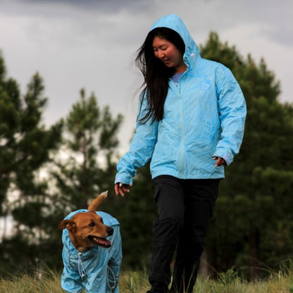 Walking the dog in matching Ripple raincoats on a wet trail 
