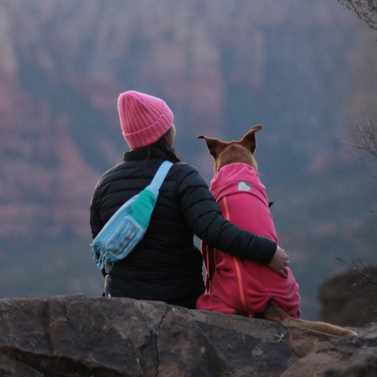 Sitting on a canyon ledge with a dog, aqua Hip Pack 2.0 worn crossbody