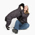 Owner hugging her black dog, both in Eclipse Puddle Jumper raincoats 