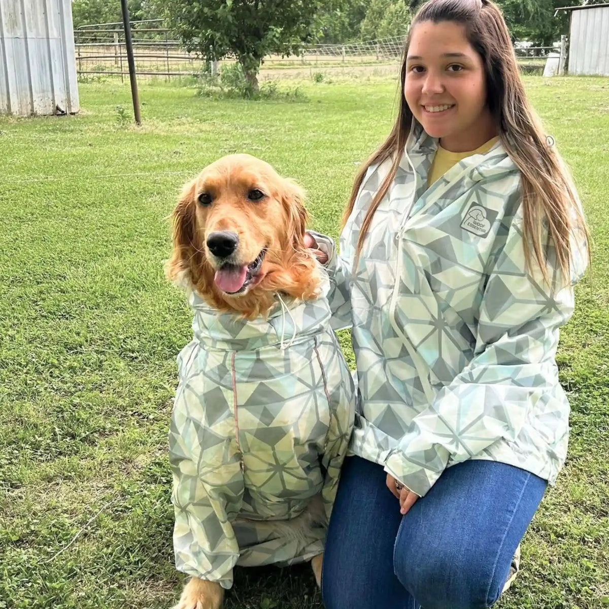 Owner and golden retriever in matching Overcast raincoats in a park 
