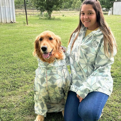Owner and golden retriever in matching Overcast raincoats in a park 