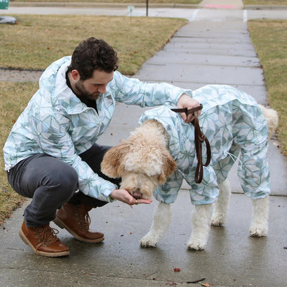 Owner and dog in matching Overcast raincoats on a wet sidewalk 