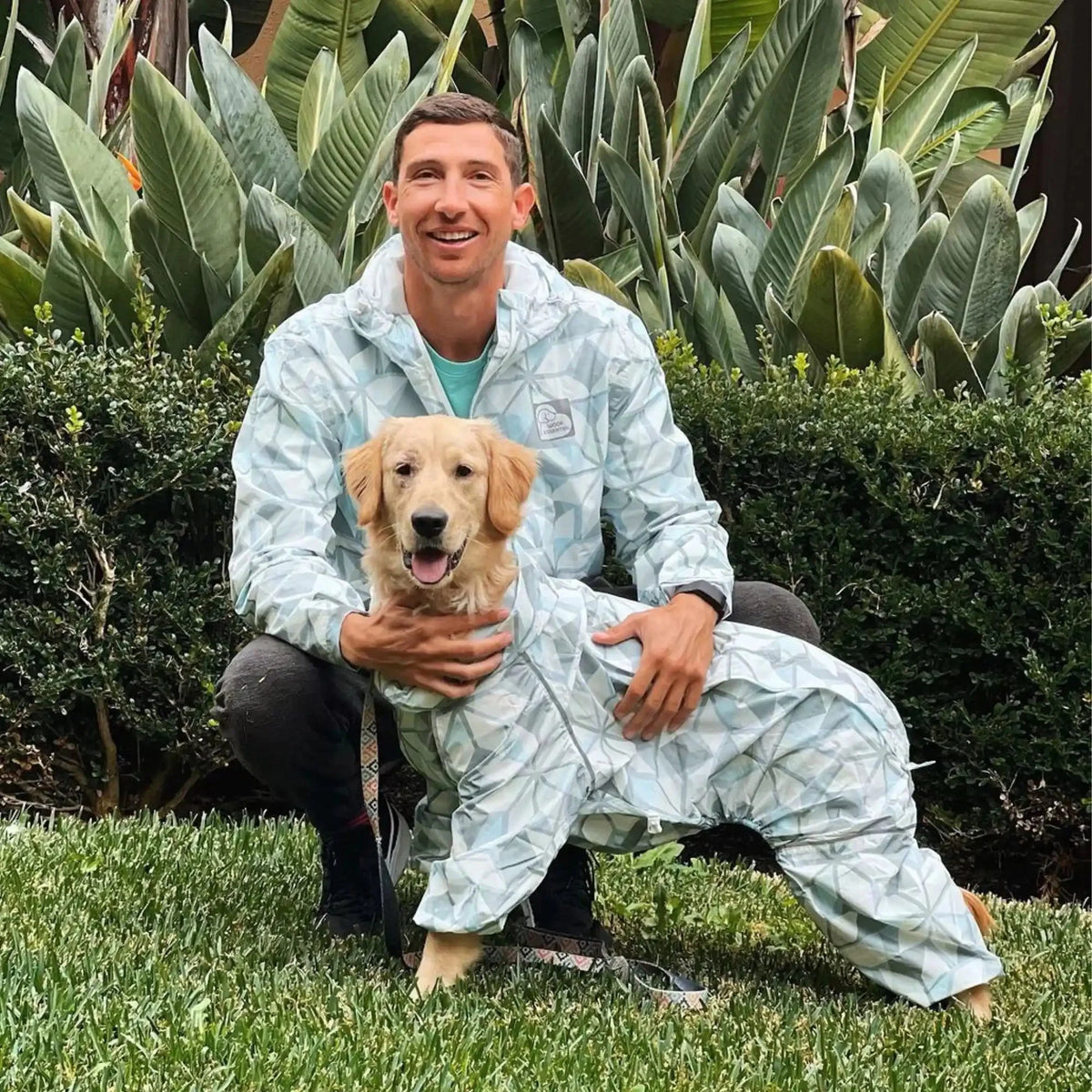 Owner and golden retriever in matching Overcast raincoats in the garden 