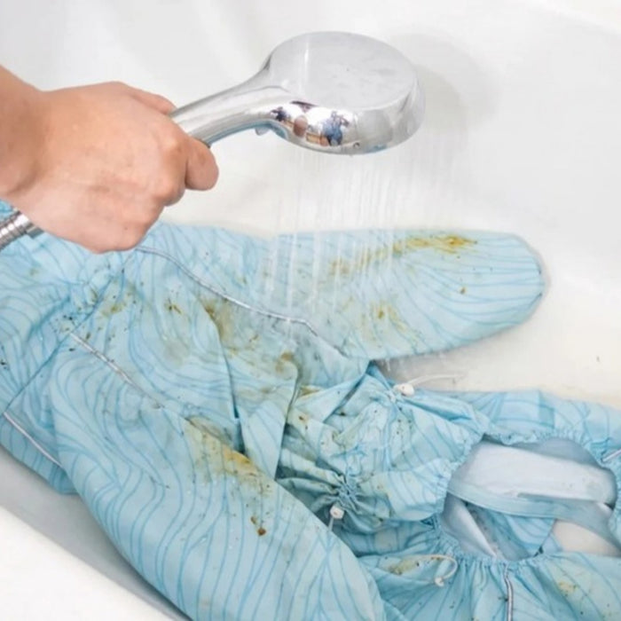 Rinsing mud off the Puddle Jumper raincoat with a shower head