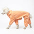 Standard poodle walking in the Snow Warrior dog snowsuit in Sunset orange, side view 